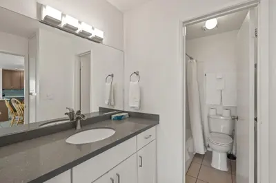 a bathroom with a sink and a toilet and a mirror at Belmont Modern - Ocean View, Pet Friendly, Patio in San Diego