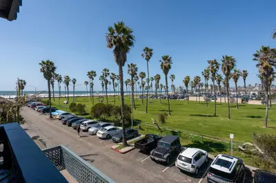 a parking lot with palm trees and a beach at Belmont Modern - Ocean View, Pet Friendly, Patio in San Diego