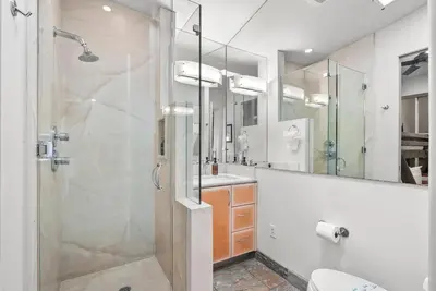 a bathroom with a glass shower and a sink at Stunning Oceanfront Boardwalk Condo - Spa, Steps2Beach, Parking & Fast Wifi! in San Diego