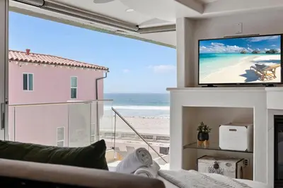 a living room with a view of the beach at Stunning Oceanfront Boardwalk Condo - Spa, Steps2Beach, Parking & Fast Wifi! in San Diego