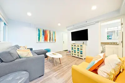 a living room with a couch and a tv at Stunning South Mission Home with Private Rooftop & Ocean Views! in San Diego