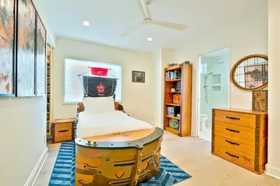 a bedroom with a bed and a table in a room at Windansea Beach Luxury - Spa, AC, Walk2Beach, Garage & fast WiFi in San Diego