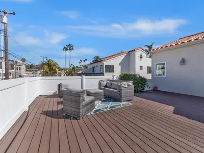 a patio with two couches on a wooden deck at Windansea Beach Luxury - Spa, AC, Walk2Beach, Garage & fast WiFi in San Diego