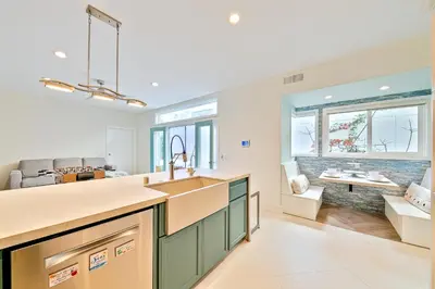 a kitchen with a sink and a living room at Windansea Beach Luxury - Spa, AC, Walk2Beach, Garage & fast WiFi in San Diego