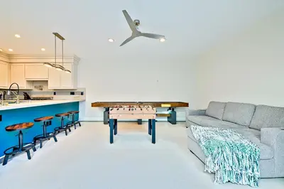 a living room with a couch and a ping pong table at Windansea Beach Luxury - Spa, AC, Walk2Beach, Garage & fast WiFi in San Diego