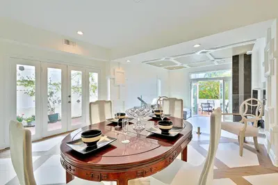 a dining room with a wooden table and chairs at Windansea Beach Luxury - Spa, AC, Walk2Beach, Garage & fast WiFi in San Diego