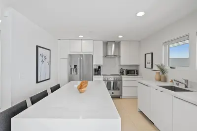 a white kitchen with a large white counter top at Birdrock Paradise w Private Pool& Spa, AC, fast WiFi & Yard! in San Diego