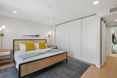 a bedroom with a bed with yellow pillows at Birdrock Paradise w Private Pool& Spa, AC, fast WiFi & Yard! in San Diego