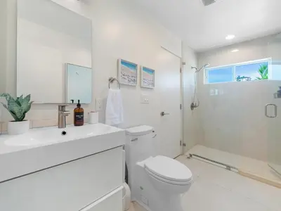a white bathroom with a toilet and a shower at Birdrock Paradise w Private Pool& Spa, AC, fast WiFi & Yard! in San Diego