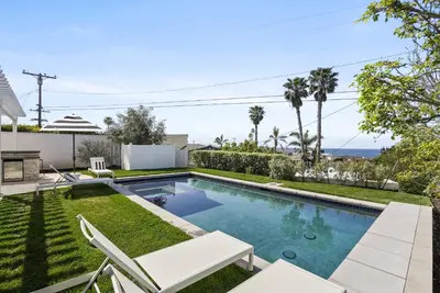 a swimming pool in a yard with two chairs at Birdrock Paradise w Private Pool& Spa, AC, fast WiFi & Yard! in San Diego