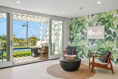 a living room with a tropical mural on the wall at Birdrock Paradise w Private Pool& Spa, AC, fast WiFi & Yard! in San Diego