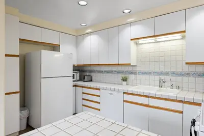 a kitchen with white cabinets and a white refrigerator at Pacific Oasis - Large Patio, Parking & Walk to Beach in San Diego