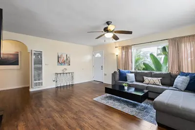 a living room with a couch and a ceiling fan at Pacific Oasis - Large Patio, Parking & Walk to Beach in San Diego