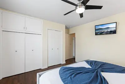a bedroom with white cabinets and a ceiling fan at Pacific Oasis - Large Patio, Parking & Walk to Beach in San Diego