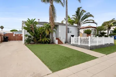 a house with a white fence and a lawn at Pacific Oasis - Large Patio, Parking & Walk to Beach in San Diego