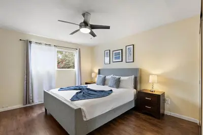 a bedroom with a bed and a ceiling fan at Pacific Paradise - Large Patio, Hot Tub, Short Walk to Beach, & Parking in San Diego