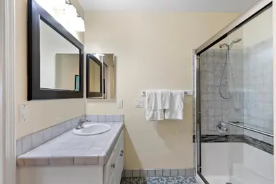 a white bathroom with a sink and a shower at Pacific Paradise - Large Patio, Hot Tub, Short Walk to Beach, & Parking in San Diego