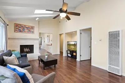 a living room with a couch and a ceiling fan at Pacific Paradise - Large Patio, Hot Tub, Short Walk to Beach, & Parking in San Diego