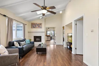 a living room with a couch and a ceiling fan at Pacific Paradise - Large Patio, Hot Tub, Short Walk to Beach, & Parking in San Diego