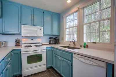 a kitchen with blue cabinets and a white stove top oven at Stunning Beach Home - Steps to the Bay,Beach, &Boardwalk w Grill & Patios in San Diego