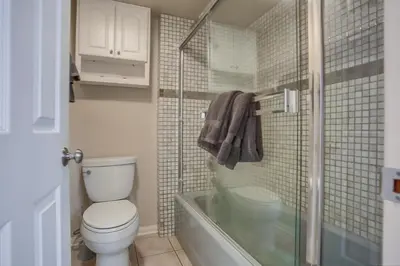 a bathroom with a toilet and a glass shower at Stunning Beach Home - Steps to the Bay,Beach, &Boardwalk w Grill & Patios in San Diego