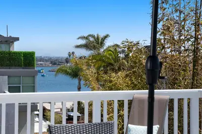 a balcony with a chair and a view of the water at Bay View Paradise - Rooftop Deck, Off-Street Parking, King Suite, WasherDryer & Bay Views! in San Diego