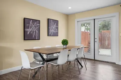 a dining room with a wooden table and white chairs at Dog Friendly Home Near the Beach with Grill, Fire Pit, Enclosed Backyard in San Diego