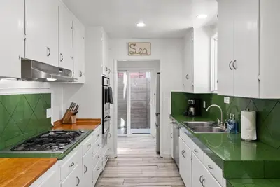 a kitchen with white cabinets and green counter tops at Bird Rock Dreams - Ocean Views, Massive Yard, Outdoor Dining, Fast Wifi & AC! in San Diego