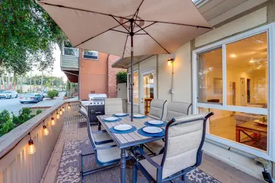 a patio with a table and chairs and an umbrella at WindnSea Beach Perfection - Walk2Beach, Pet Friendly & Parking in San Diego