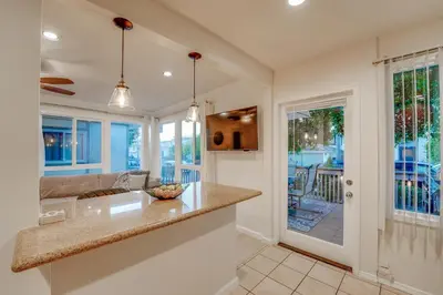 a kitchen with a counter and a living room at WindnSea Beach Perfection - Walk2Beach, Pet Friendly & Parking in San Diego