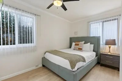 a bedroom with a bed and a ceiling fan at WindnSea Beach Perfection - Walk2Beach, Pet Friendly & Parking in San Diego