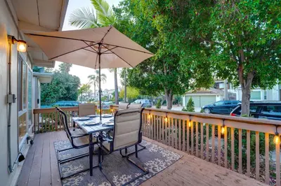 a table and chairs with an umbrella on a deck at WindnSea Beach Perfection - Walk2Beach, Pet Friendly & Parking in San Diego
