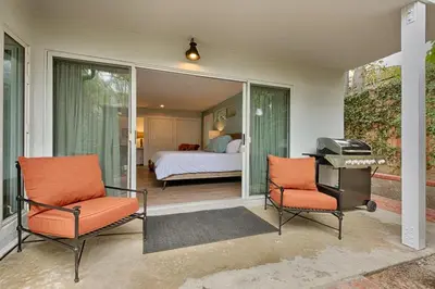 a room with two chairs and a bedroom with a bed at Shores Perfection - Spa, AC, Pet Friendly, Parking, Fire Pit & Massive Private Yard! in San Diego