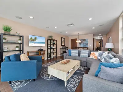 a living room with blue couches and a table at Stunning Bayfront condo with gorgeous views, garage, massive roof deck & AC - dogs welcome! in San Diego