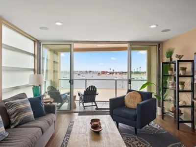 a living room with a couch and a view of the beach at Stunning Bayfront condo with gorgeous views, garage, massive roof deck & AC - dogs welcome! in San Diego