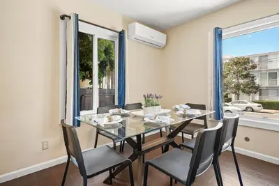 a dining room with a glass table and chairs at Riviera Bay View Dream - Private patio with bay view and parking in San Diego