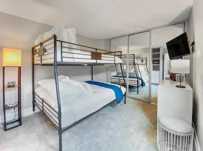 a bedroom with two bunk beds and a television at Oceanfront Condo with Front Patio, Gas Grill, Fire Pit - Prime Location!! in San Diego