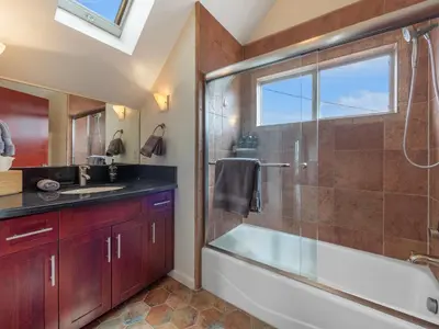 a bathroom with a tub and a shower and a sink at Ocean View Beach Haven! Steps2Beach & Pet Friendly in San Diego