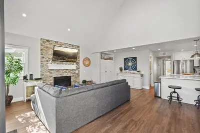 a living room with a couch and a kitchen at Stunning Beach Home with Fireplace, Fast WiFi, Grill & Outdoor Seating! in San Diego