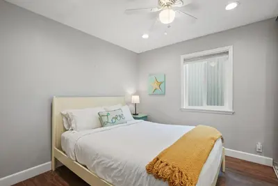 a white bedroom with a bed and a window at Stunning Beach Home with Fireplace, Fast WiFi, Grill & Outdoor Seating! in San Diego
