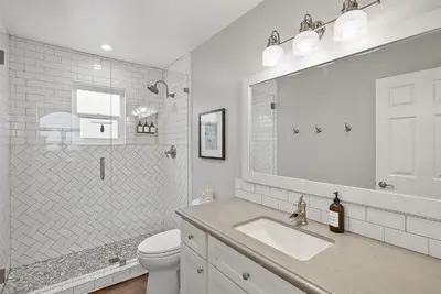 a bathroom with a sink and a toilet and a mirror at Stunning Beach Home with Fireplace, Fast WiFi, Grill & Outdoor Seating! in San Diego