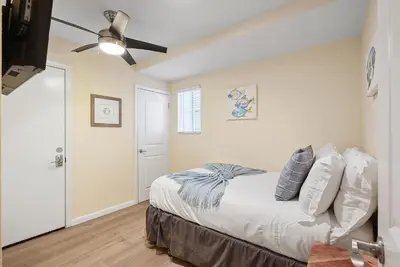 a bedroom with a bed and a ceiling fan at Stunning Beach Delight with Hot Tub, Fire Pit, Parking & Walk to Beach! in San Diego