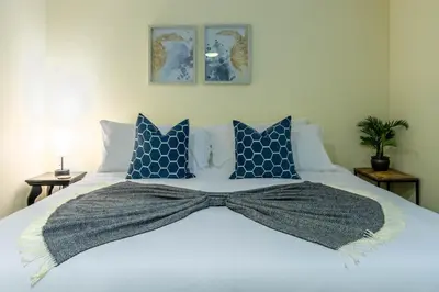a large bed with a bow tie on it at Stunning Beach Delight with Hot Tub, Fire Pit, Parking & Walk to Beach! in San Diego