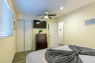 a bedroom with a bed and a ceiling fan at Stunning Beach Delight with Hot Tub, Fire Pit, Parking & Walk to Beach! in San Diego