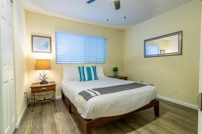 a bedroom with a bed and a window at Stunning Beach Delight with Hot Tub, Fire Pit, Parking & Walk to Beach! in San Diego