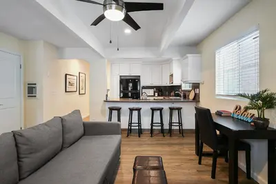 a living room with a couch and a table at Stunning Beach Delight with Hot Tub, Fire Pit, Parking & Walk to Beach! in San Diego