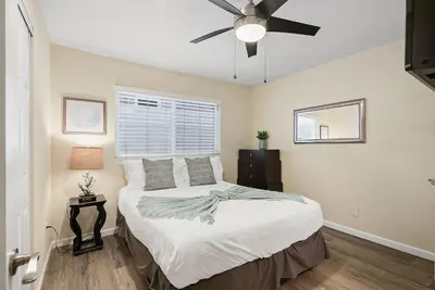 a bedroom with a bed and a ceiling fan at Stunning Beach Delight with Hot Tub, Fire Pit, Parking & Walk to Beach! in San Diego