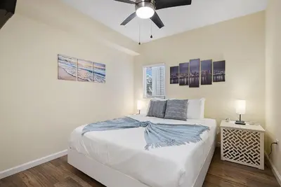 a bedroom with a bed and a ceiling fan at Beach Perfection - Ocean Views, Parking, Pet Friendly & Steps2Sand in San Diego