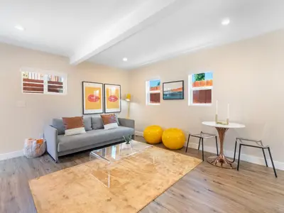 a living room with a couch and a table at Beach Bungalow Perfection - Private Patios, BBQ walk2beach & Pet Friendly! in San Diego