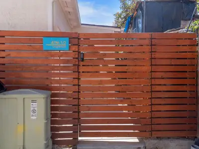 a wooden fence with a blue sign on it at Beach Bungalow Perfection - Private Patios, BBQ walk2beach & Pet Friendly! in San Diego